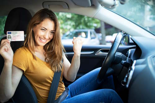 Femme en voiture qui motre son permis de conduire