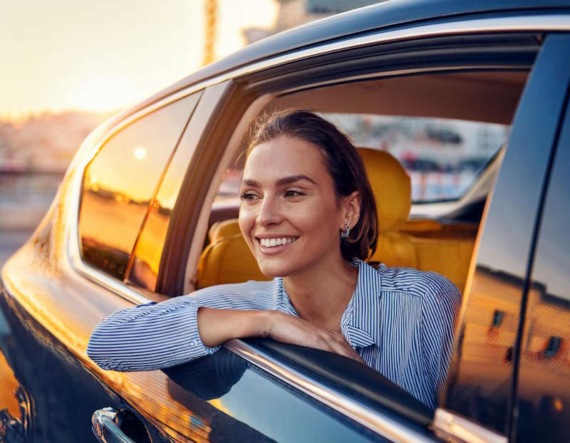 Passagère souriante dans un taxi longue distance